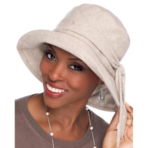 May include: A beige sun hat with a wide brim and a tie at the back. The hat is made of a soft, comfortable fabric.