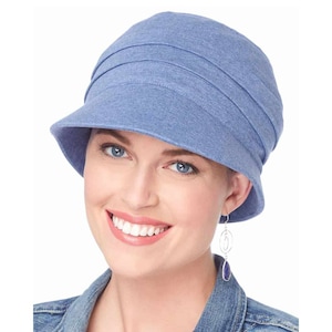 May include: A blue denim fabric hat with a wide brim and a folded crown. The hat is made of a soft, comfortable material and has a casual, relaxed style.