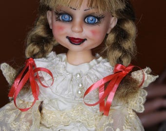 May include: A vintage doll with a porcelain face, blue eyes, and red lips. The doll has blonde hair styled in pigtails with red ribbons. She wears a white dress with lace sleeves and a pearl-adorned neckline. The doll's cheeks are blushed.