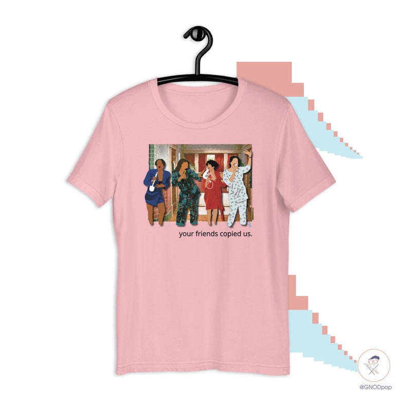 May include: Pink t-shirt with a graphic of four people in pajamas standing in a hallway. The text "your friends copied us." is printed below the graphic.
