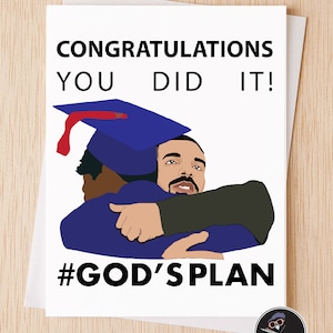 May include: A white card with black text that reads "Congratulations You Did It!" and a cartoon image of two men hugging. One man is wearing a blue graduation cap and gown. The text "#GOD'S PLAN" is below the image.