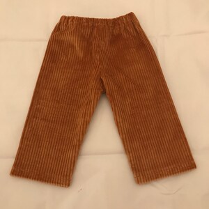 May include: A pair of brown corduroy trousers with a wide leg.