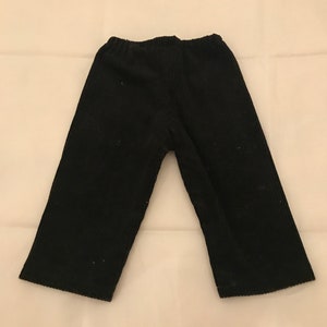 May include: Black corduroy trousers with a straight leg and a wide waistband.