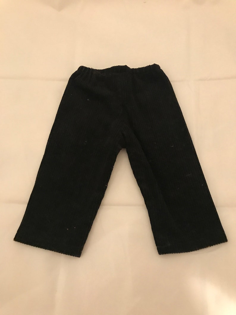 May include: Black corduroy trousers with a straight leg and a wide waistband.