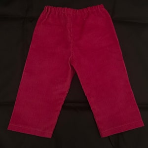 May include: A pair of burgundy corduroy trousers with an elastic waistband.