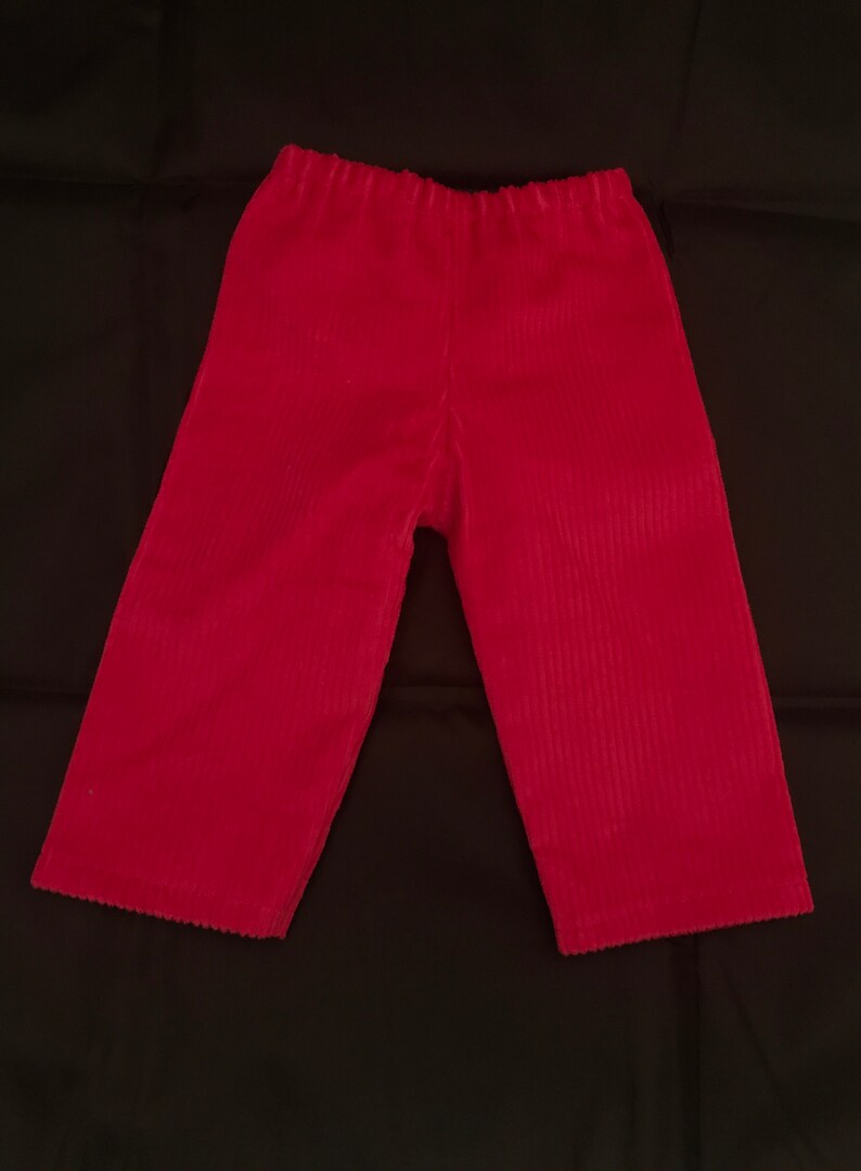 May include: A pair of red corduroy trousers with a wide leg and elastic waistband.