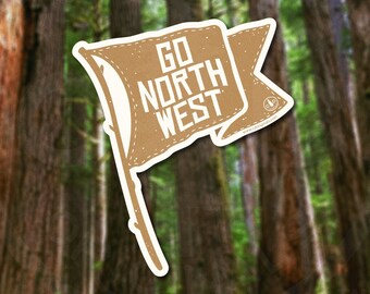 May include: A brown sticker in the shape of a flag with the words "GO NORTH WEST" in white. The sticker is set against a blurred background of a forest with tall trees.