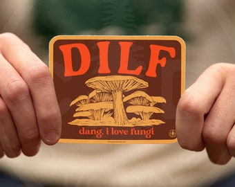 May include: A brown and orange sticker with the text "DILF" in large, bold, orange letters. Below the text is a drawing of mushrooms and the text "dang, i love fungi".