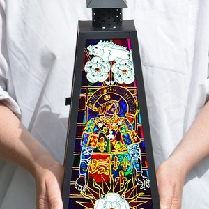 May include: A black metal lantern with a stained glass design. The glass features a colorful image of a person in armor, a white boar, and white roses. The text "RICARDUS III REX" is visible on the glass.