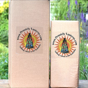 May include: Two cardboard boxes with a logo on the front. The logo is a circle with a sunburst design and the text "www.Ornately Lanterns.com Adding colour to the sunshine".