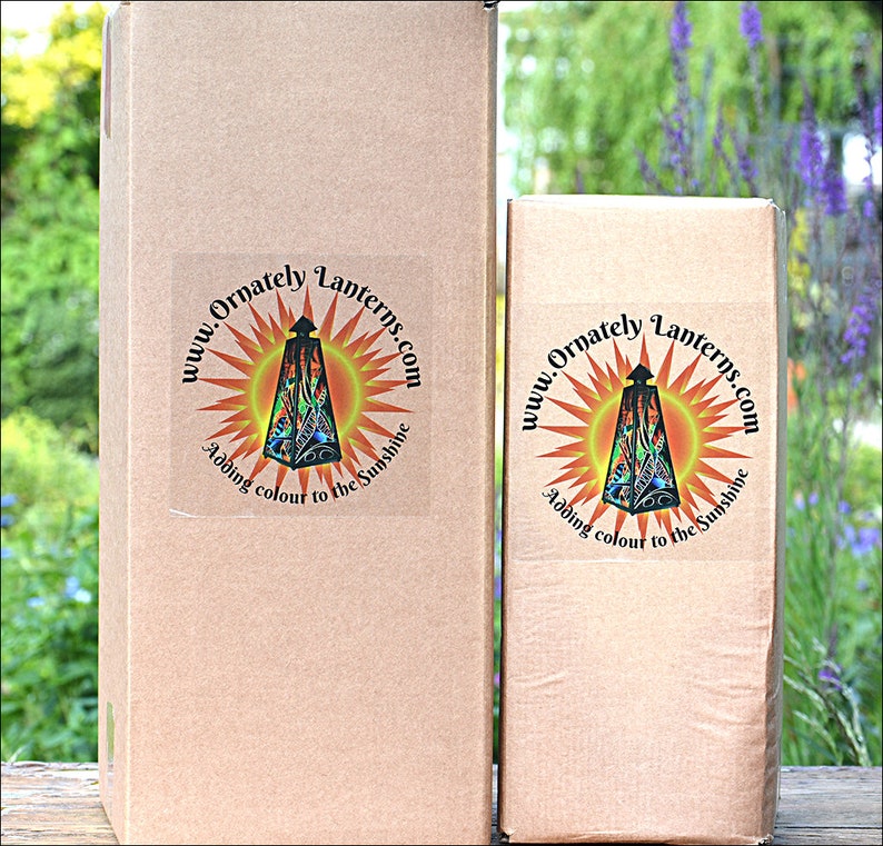 May include: Two cardboard boxes with a logo on the front. The logo is a circle with a sunburst design and the text "www.Ornately Lanterns.com Adding colour to the sunshine".