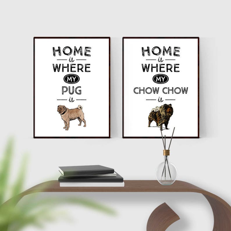 May include: Two black framed prints with white backgrounds. The print on the left says "Home is where my pug is" and features a brown pug. The print on the right says "Home is where my chow chow is" and features a brown chow chow.
