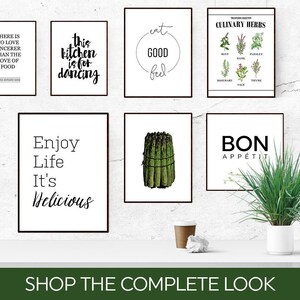 May include: A collection of eight black framed prints with white backgrounds and black text. The prints feature various kitchen-themed quotes, including "Eat Good Feel Good", "This Kitchen is for Dancing", "Enjoy Life It's Delicious", and "Bon Appetit".