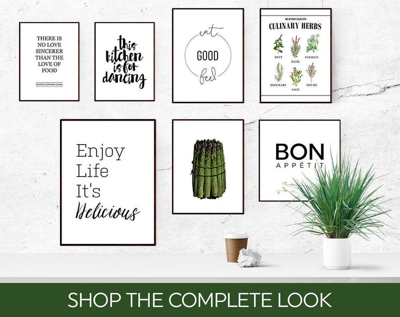 May include: A collection of eight black framed prints with white backgrounds and black text. The prints feature various kitchen-themed quotes, including "Eat Good Feel Good", "This Kitchen is for Dancing", "Enjoy Life It's Delicious", and "Bon Appetit".