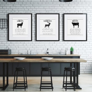 Puede incluir: Tres carteles enmarcados en negro con fondos blancos colgados en una pared de ladrillo blanco. Los carteles est&aacute;n etiquetados como "Lamb Cuts", "Venison Cuts" y "Beef Cuts" y cada uno presenta una silueta negra del animal con cortes de carne etiquetados.