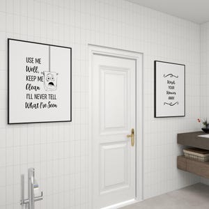 A white door flanked by two black-framed minimalist bathroom art prints on a white tiled wall.