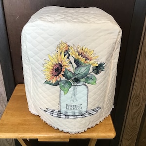 May include: A white quilted kitchen appliance cover with a floral design featuring sunflowers in a mason jar. The jar has the text "Perfect Mason" printed on it.