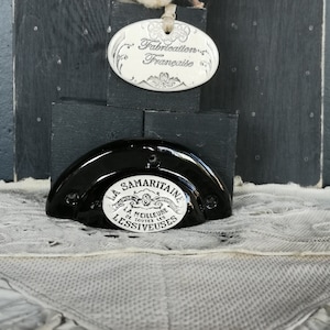Peut inclure: Poignée de porte en céramique noire avec une étiquette en porcelaine blanche qui indique "La Samaritaine, La Meilleure de Toutes Les Lessiveuses".