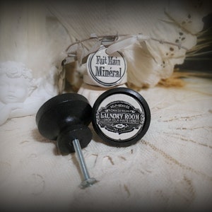 Peut inclure: Bouton de porte en céramique noire avec un insert en porcelaine blanche avec le texte "Self-Service Ouvert 24 Heures Buanderie Laissez vos pantalons ici".