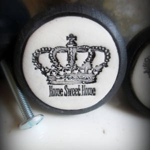 May include: Black and white ceramic knob with a crown design and the text "Home Sweet Home".