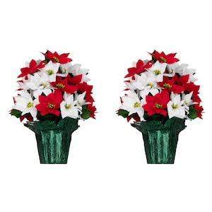 May include: Two artificial poinsettia flower arrangements. Each arrangement features red and white flowers with green leaves, presented in a green decorative pot. The flowers are clustered together, creating a full and vibrant display, perfect for holiday decor.