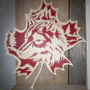Recorte de lobo blanco sobre hoja de arce roja, ilustración dibujada a mano en cartulina, pieza de papel con diseño de animales, marcapáginas o tarjeta decorativa.