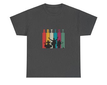 Op de afbeelding: Een donkergrijs t-shirt met een retro-stijl grafische afbeelding van een band die muziek maakt. De afbeelding toont een drummer, een gitarist en een zanger met het woord "ARTIST" in kleurrijke letters erboven.