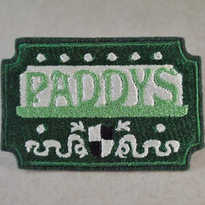 May include: Green embroidered patch with the word "PADDY'S" in white lettering with a green shamrock design.
