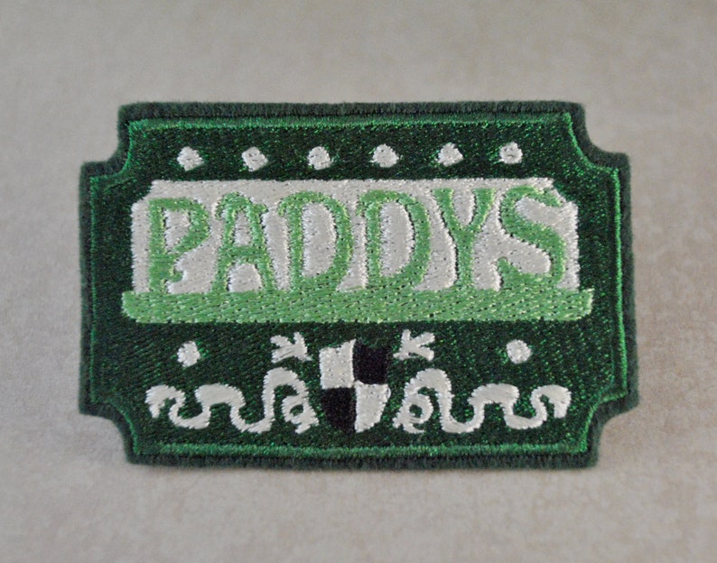 May include: Green embroidered patch with the word "PADDY'S" in white lettering with a green shamrock design.