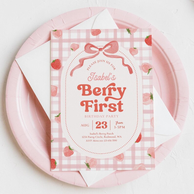 Peut inclure: Une invitation rose et blanche pour la f&ecirc;te d'anniversaire Berry First d'Isabel. L'invitation pr&eacute;sente un motif vichy rose avec des illustrations de fraises. Le texte comprend la date, l'heure et le lieu.