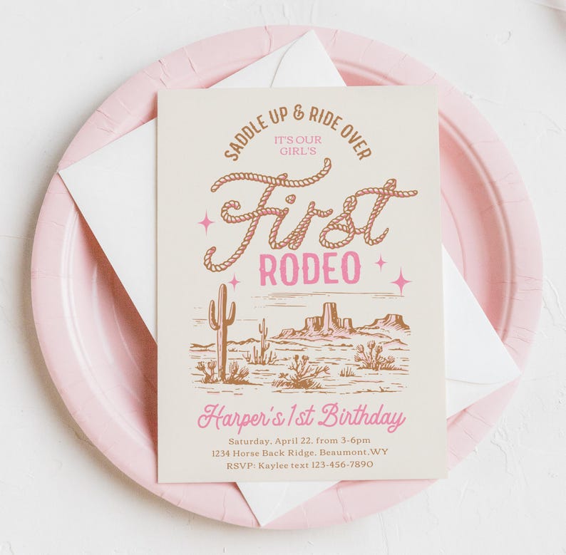 May include: A pink and white invitation with a brown illustration of a desert landscape. The text reads "Saddle Up & Ride Over It's Our Girl's First Rodeo" and "Harper's 1st Birthday".