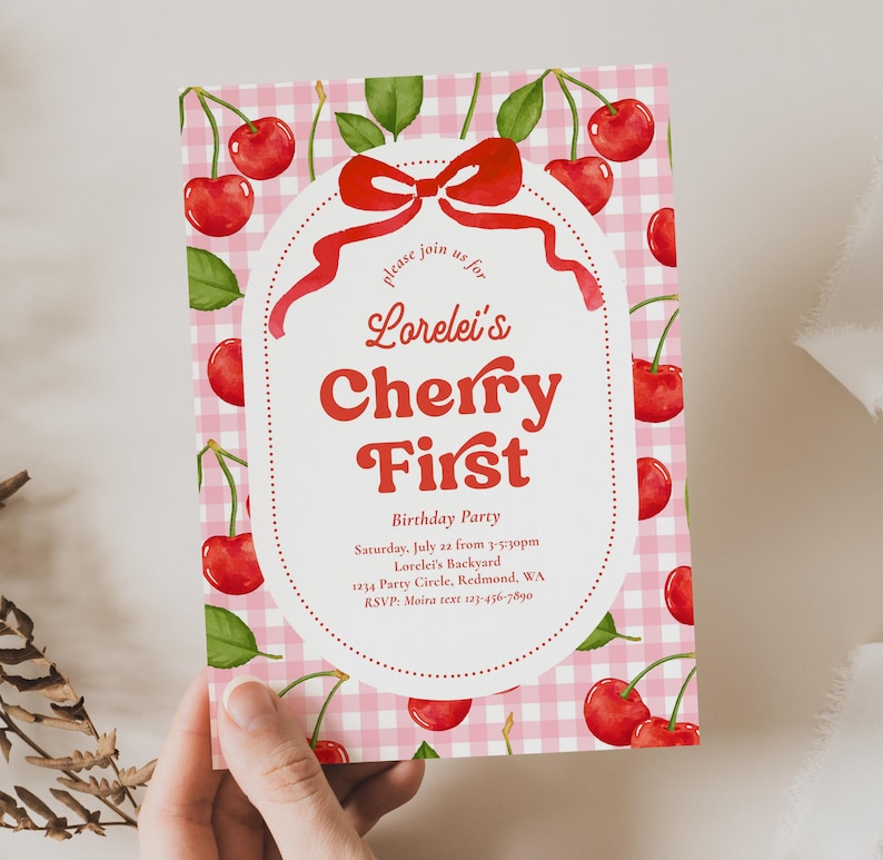 May include: A pink and white gingham patterned invitation with watercolor cherries and green leaves. The invitation reads "Lorelei's Cherry First Birthday Party" in red script and bold font. Includes event details.