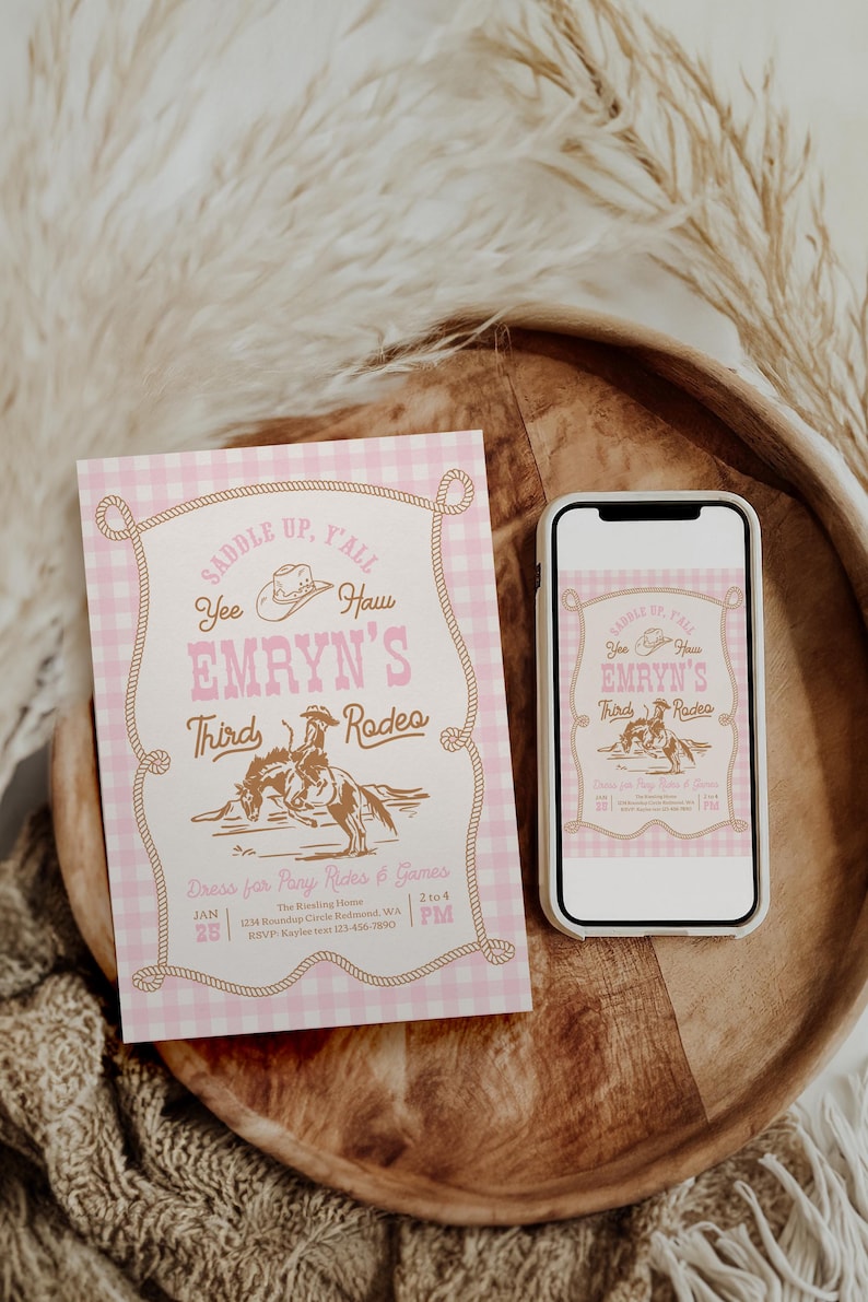 May include: A rectangular invitation card and a smartphone displaying the same design, featuring a pink and white gingham background, a brown rope border, a cowboy hat, and a rider on a horse with the text "Saddle Up, Y'all Yee Haw Emryn's Third Rodeo".