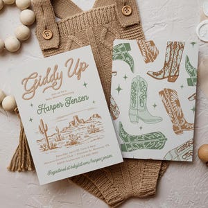 May include: A baby shower invitation with a western theme. The invitation features a desert landscape with cacti and mountains. The text reads "Giddy Up" and "Harper Jensen".