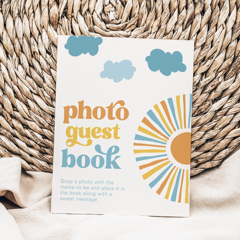 K&ouml;nnte beinhalten: Eine wei&szlig;e Karte mit einem Retro-Design mit einer Sonne, Wolken und dem Text "photo guest book". Der Text unter dem Titel lautet "Machen Sie ein Foto mit der werdenden Mutter und legen Sie es zusammen mit einer s&uuml;&szlig;en Nachricht in das Buch."