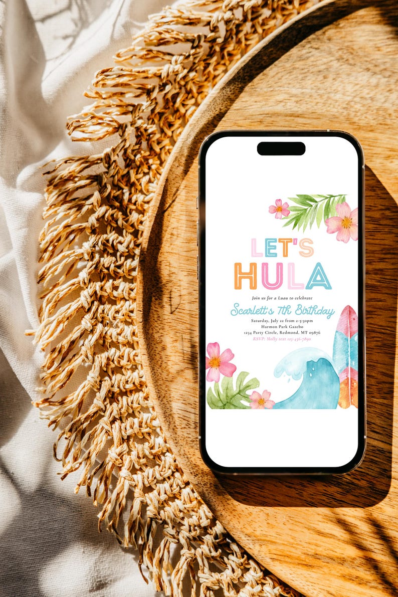 May include: A smartphone displays a colorful invitation with the text "Let's Hula" for Scarlett's 7th birthday. The design includes pink flowers, green leaves, a wave, and a surfboard. The phone rests on a wooden tray.