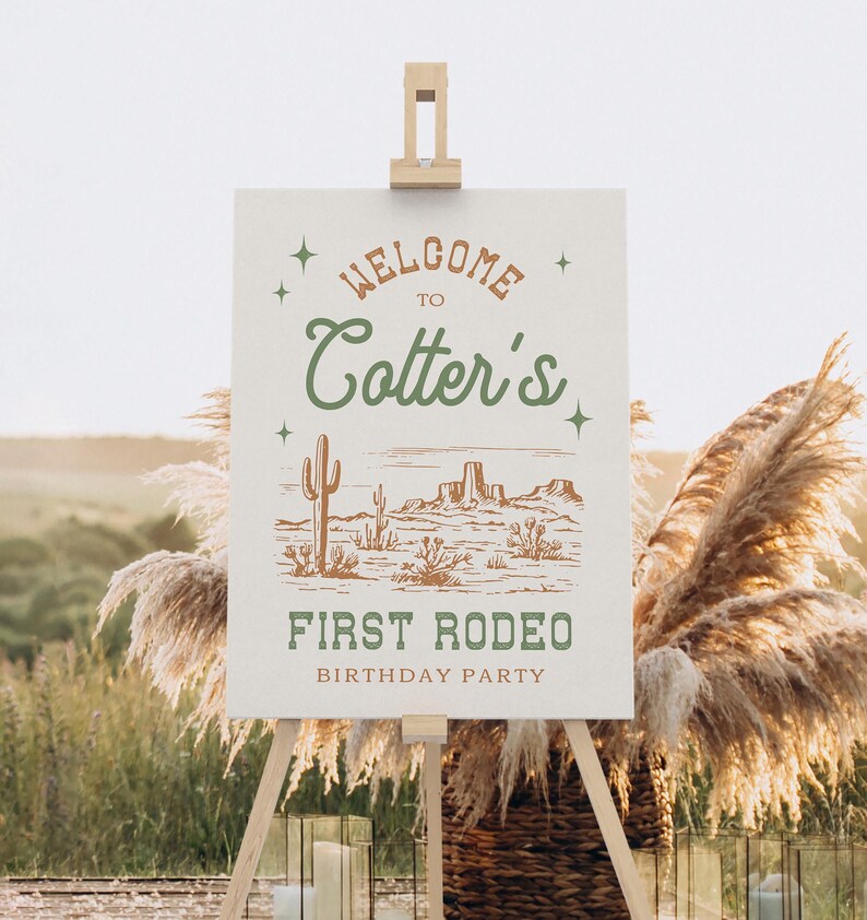 K&ouml;nnte beinhalten: Ein wei&szlig;es Schild mit braunem und gr&uuml;nem Text, auf dem "Willkommen zu Cotter's First Rodeo Birthday Party" steht. Das Schild zeigt eine Zeichnung einer W&uuml;stenlandschaft mit Kakteen und Bergen.