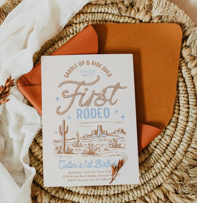 May include: A white invitation with a blue and brown illustration of a cowboy boot and the text "Saddle Up & Ride Over It's Our Boy's First Rodeo". The invitation is for Cotter's 1st Birthday party on Saturday, April 22nd from 3-6pm at 1234 Horse Back Ridge, Beaumont, TX. RSVP to Kaylee at 123-456-7890.