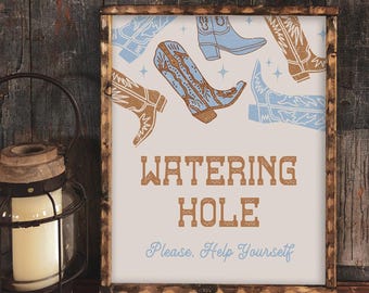 May include: A white sign with brown text that reads "Watering Hole" and "Please Help Yourself". The sign is decorated with blue and brown cowboy boots.
