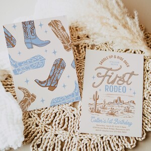 May include: A light blue and brown cowboy boot pattern on a white background. A white invitation with brown text reads "Saddle Up & Ride Over It's Our Boy's First Rodeo" with a drawing of a desert landscape. The text below reads "Cotter's 1st Birthday Saturday, April 22, from 3-6pm 1234 Horse Back Ridge, Beaumont, WY RSVP Kaylee text 123-456-7890"