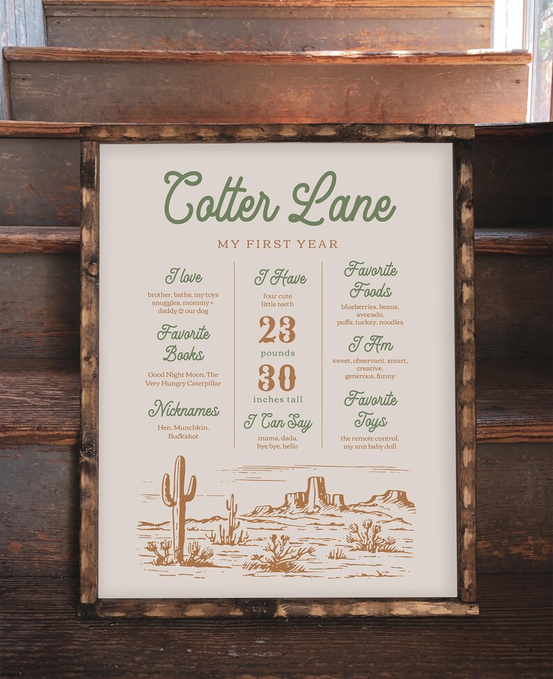K&ouml;nnte beinhalten: Ein beige-braunes illustriertes Poster mit dem Text "Cotter Lane Mein erstes Jahr". Das Poster listet die Lieblingsdinge eines Kindes auf, darunter B&uuml;cher, Lebensmittel, Spielzeug und Aktivit&auml;ten. Das Poster ist mit einer W&uuml;stenlandschaft-Illustration verziert.