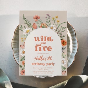 Puede incluir: Una invitación a una fiesta de cumpleaños con temática floral con un fondo melocotón y un arco blanco. El texto dice "Wild and Five" en una fuente retro, seguido de "Hallie's 5th birthday party". La invitación incluye detalles para la fiesta, incluyendo la fecha, la hora, la ubicación y la información de RSVP.