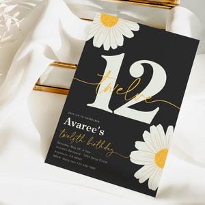 May include: Black and white birthday invitation with a large white number 12 with gold lettering that says "twelve". The invitation has a white daisy with a yellow center on the top and bottom of the card. The text on the invitation reads "Join us to celebrate Avaree's twelfth birthday Saturday, May 22, 4-7pm Avaree's Backyard - 1234 Daisy Circle Anywhere, CA 98007 RSVP: Molly text 123-456-7890"