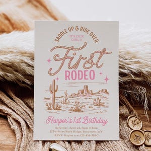 May include: A pink and brown invitation for a first rodeo themed birthday party. The invitation features a hand-drawn illustration of a desert landscape with cacti and mountains. The text reads "Saddle Up & Ride Over It's Our Girl's First Rodeo Harper's 1st Birthday Saturday, April 22, from 3-6pm 1234 Horse Back Ridge, Beaumont, WY RSVP: Kaylee text 123-456-7890"