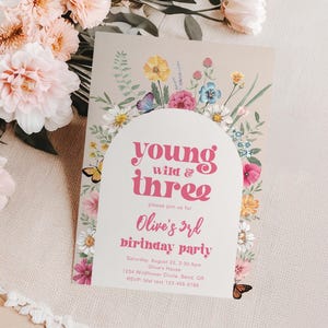 May include: A pink and white birthday party invitation with a floral design and the text "young wild & three" and "Olive's 3rd birthday party".