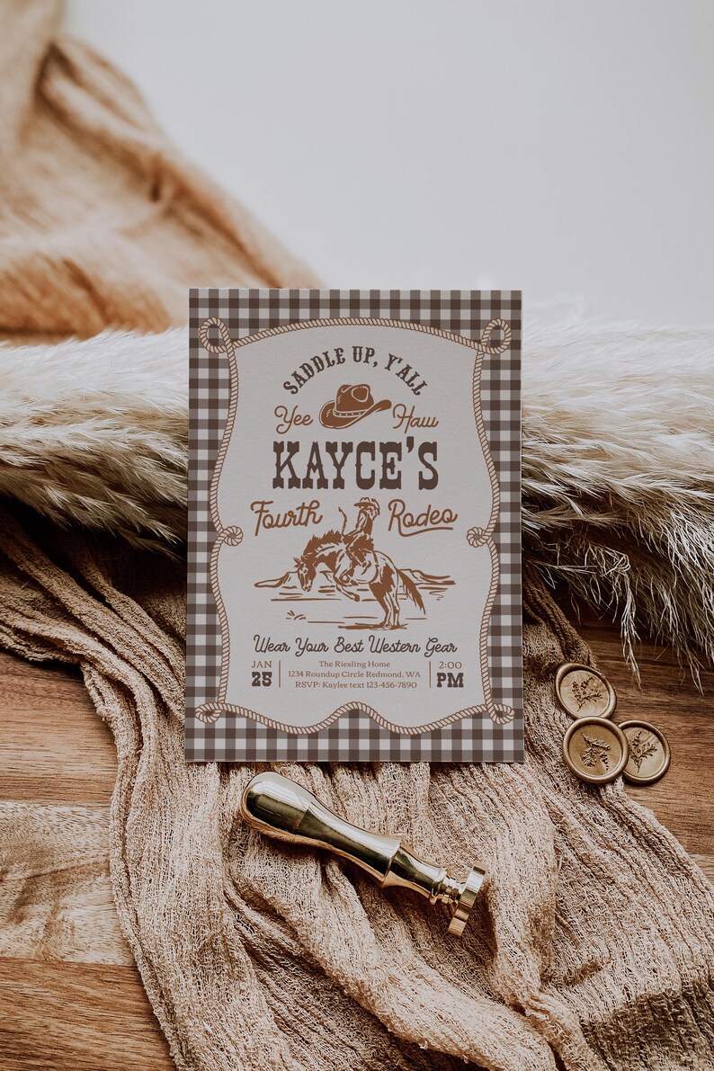 Op de afbeelding: Een rechthoekige uitnodigingskaart met een bruin-witte vichy-ruitrand. Het midden bevat bruine tekst met "Saddle Up, Y'all", "Yee Haw", "Kayce's Fourth Rodeo" en "Wear Your Best Western Gear", inclusief een illustratie van een cowboy op een paard.