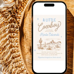 Op de afbeelding: Een digitale uitnodiging voor een babyshower met een cowboythema. De uitnodiging heeft een blauw en wit touwontwerp met de tekst "A Little Cowboy is on the way". De uitnodiging bevat ook een tekening van een woestijnlandschap met cactussen en bergen.