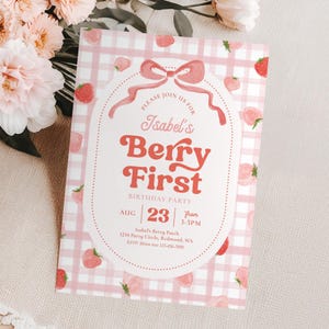 Peut inclure: Une invitation rose et blanche &agrave; carreaux avec le texte "Isabel's Berry First Birthday Party". L'invitation pr&eacute;sente un th&egrave;me de fraise, avec des illustrations de fraises et un n&oelig;ud rose.