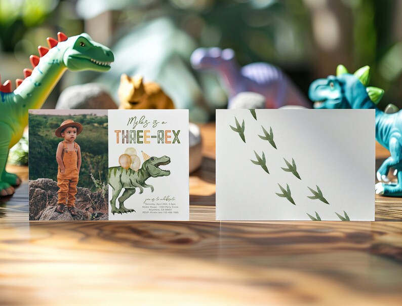 May include: A dinosaur-themed birthday invitation with a photo of a child wearing a hat and overalls. The invitation says "Myles is a THREE-REX" and features a green dinosaur with a party hat and balloons. The back of the invitation has a white background with green dinosaur footprints.
