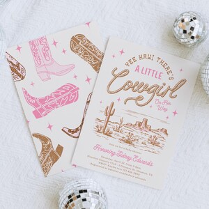 May include: A pink and brown baby shower invitation with a western theme. The invitation features a drawing of a desert landscape with cacti and the text "Yee Hawi There's A Little Cowgirl On Her Way".